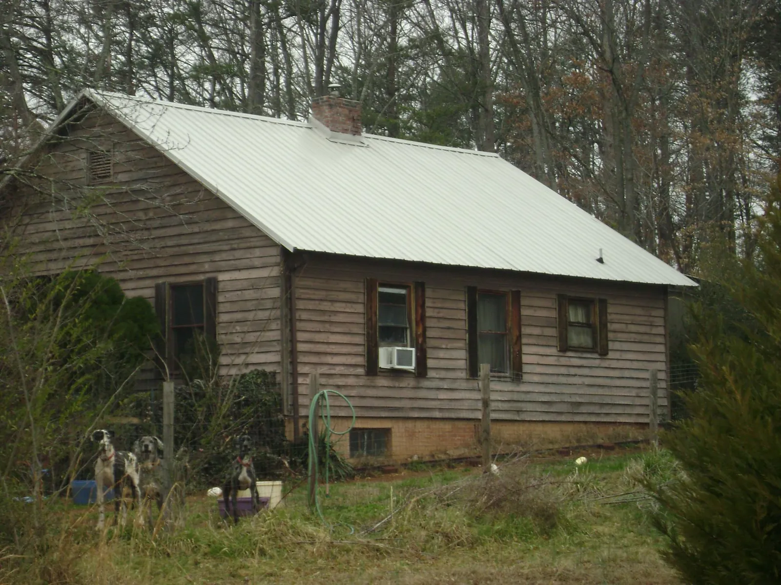 White metal roof on an old wood sided farmhouse, from a Metal Roof Installation job in Winston